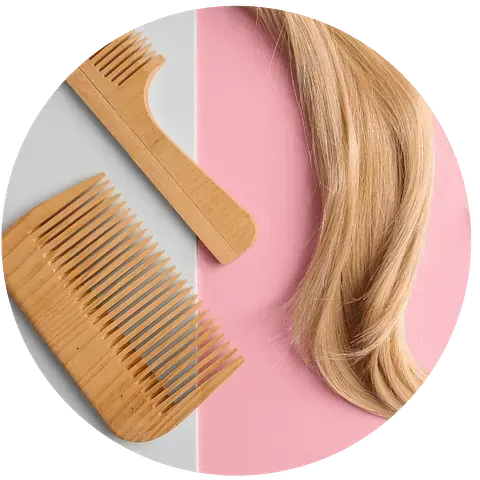 Dos peines de madera y una muestra de cabello rubio sobre un fondo rosa y gris.