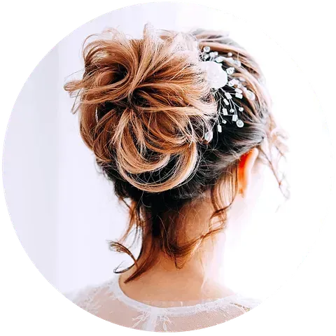 Mujer con peinado de moño desordenado, adornado con accesorios para el cabello de flores y ramitas.