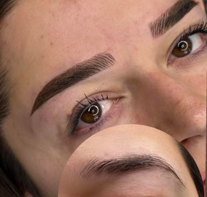 Nahaufnahme des Auges einer Person mit dunklen, vollen Wimpernverlängerungen und gepflegten Augenbrauen.