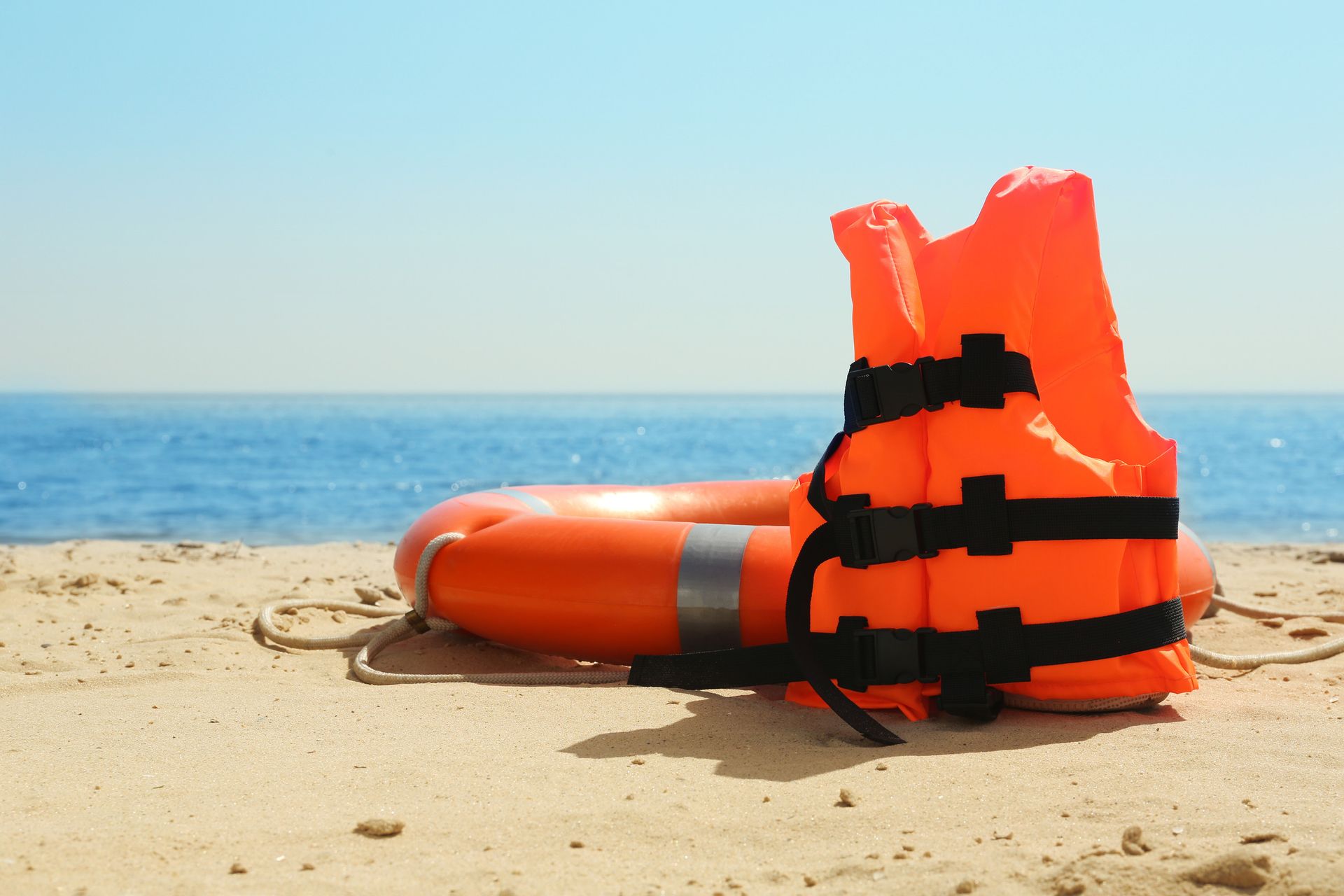 Un chaleco salvavidas y un chaleco salvavidas están en la playa.