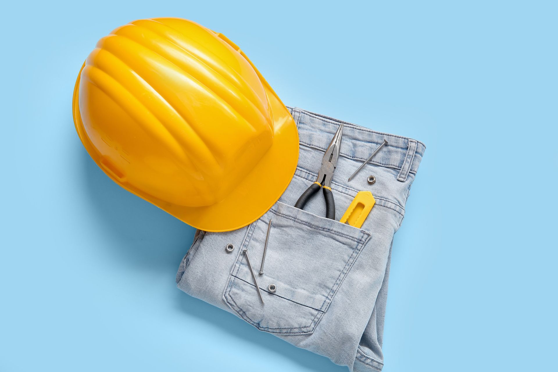 Un casco amarillo está encima de un par de jeans.