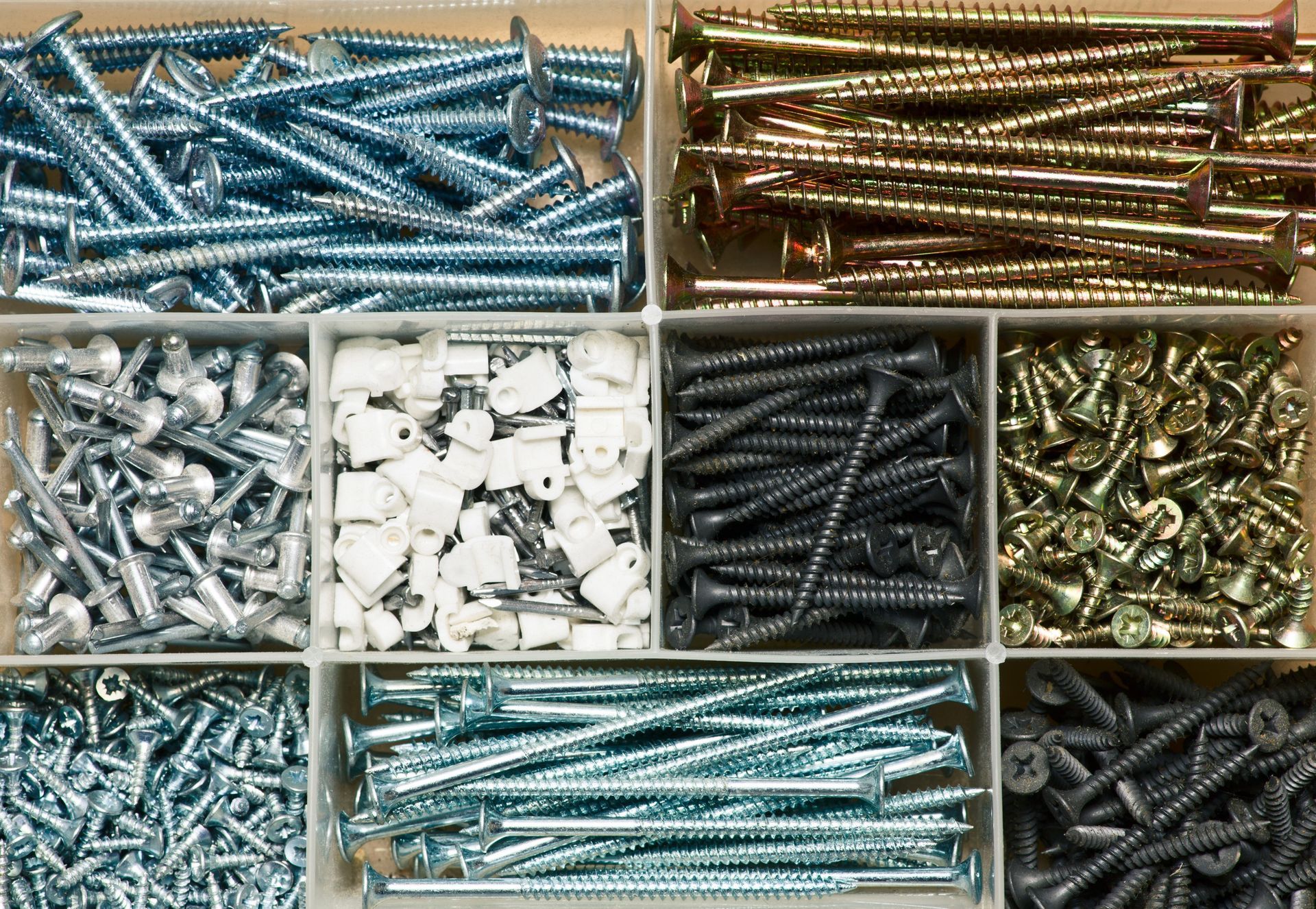 Una caja llena de diferentes tipos de tornillos y clavos.