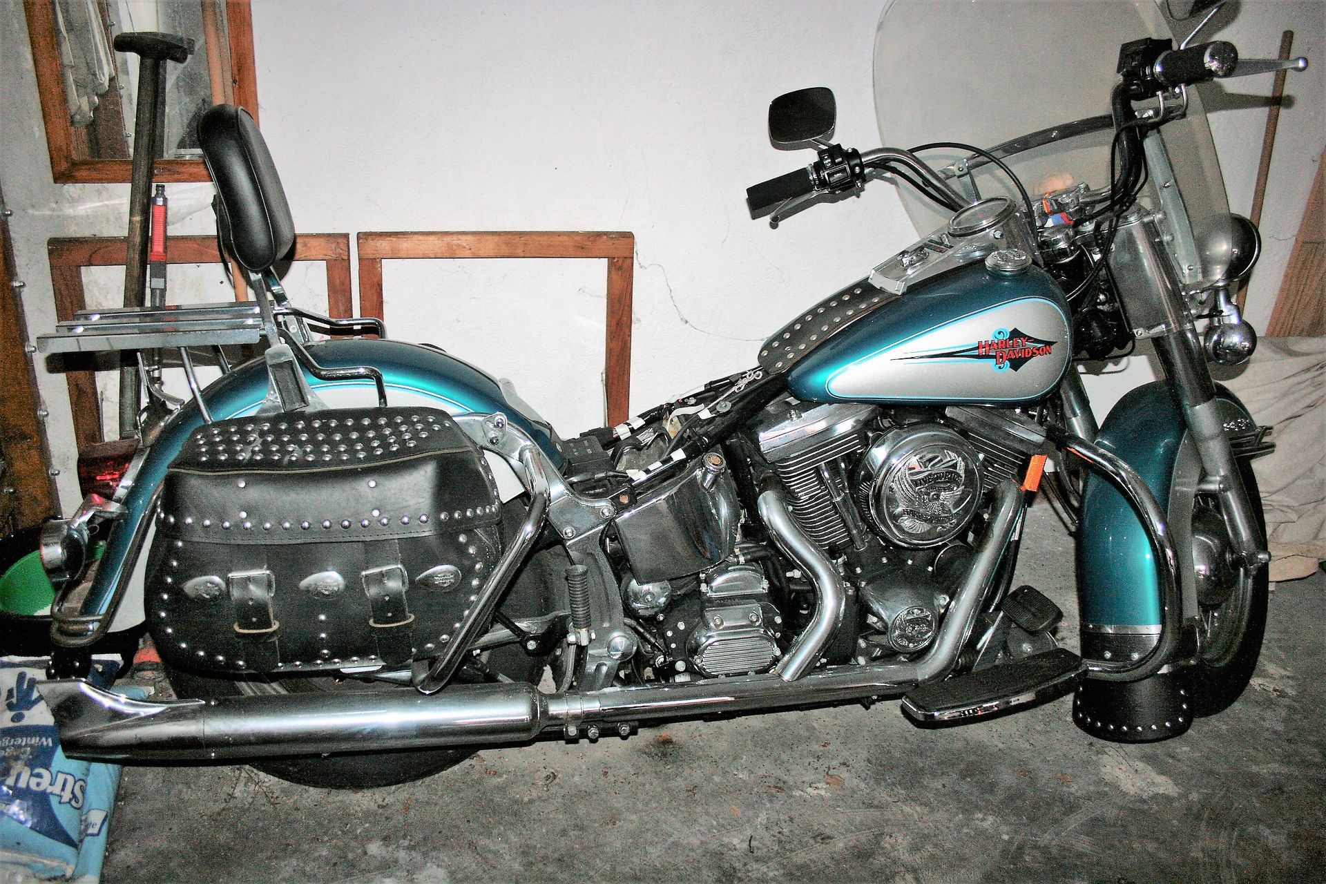 Blau-silbernes Harley-Davidson-Motorrad mit Nieten besetztem Ledersattel und Ledertaschen, Windschutzscheibe und Rückenlehne.
