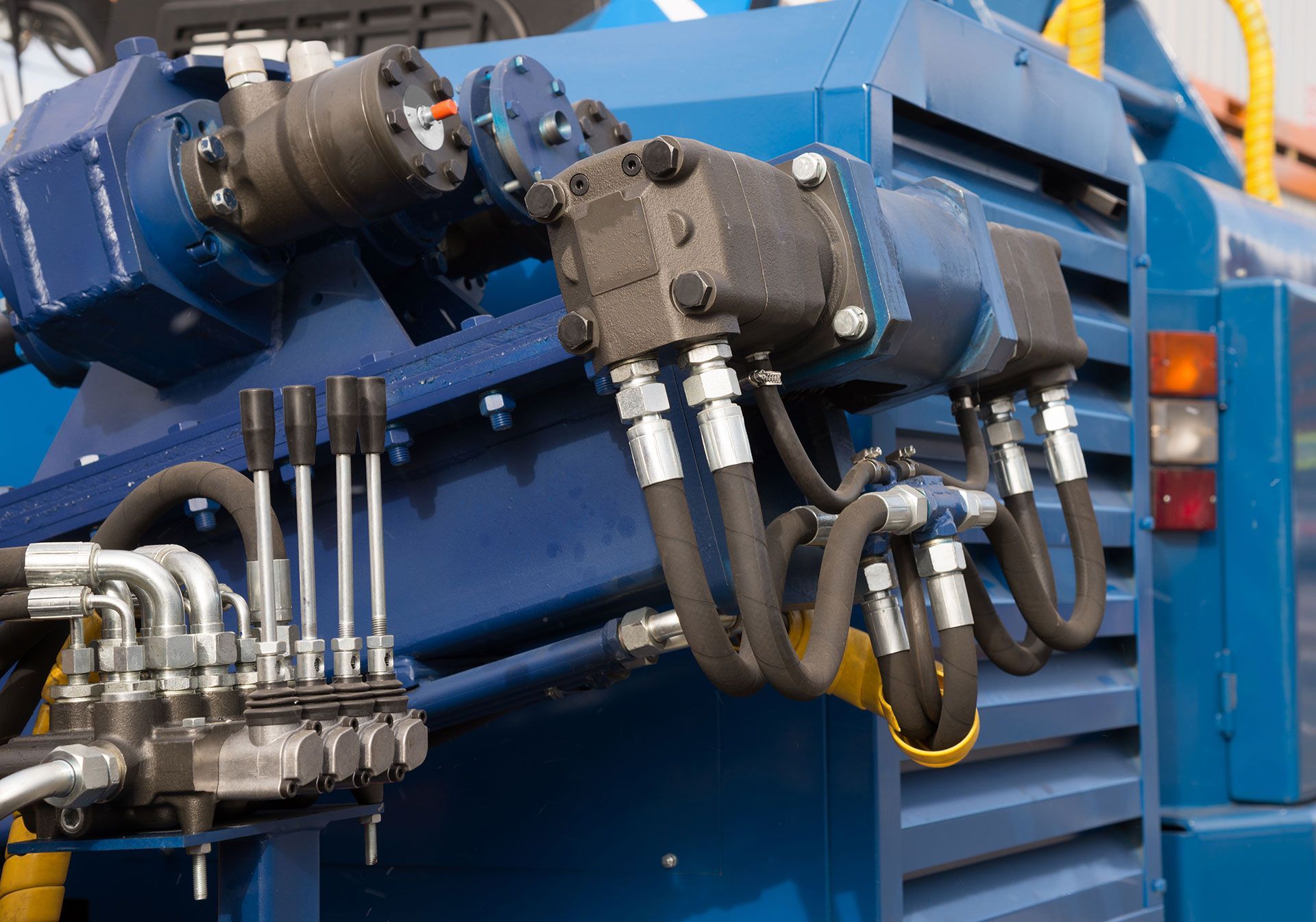 Machines hydrauliques bleues avec tuyaux et vannes montées sur un camion