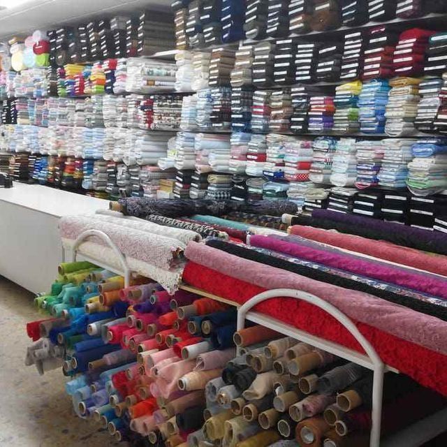 Una tienda llena de telas de muchos colores diferentes.