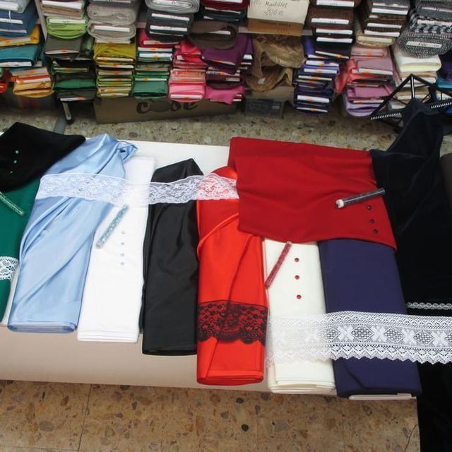 Un montón de ropa está apilada una encima de otra sobre una mesa.