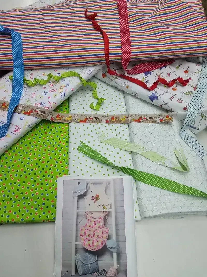 Un montón de telas y cintas están colocadas una encima de otra sobre una mesa.