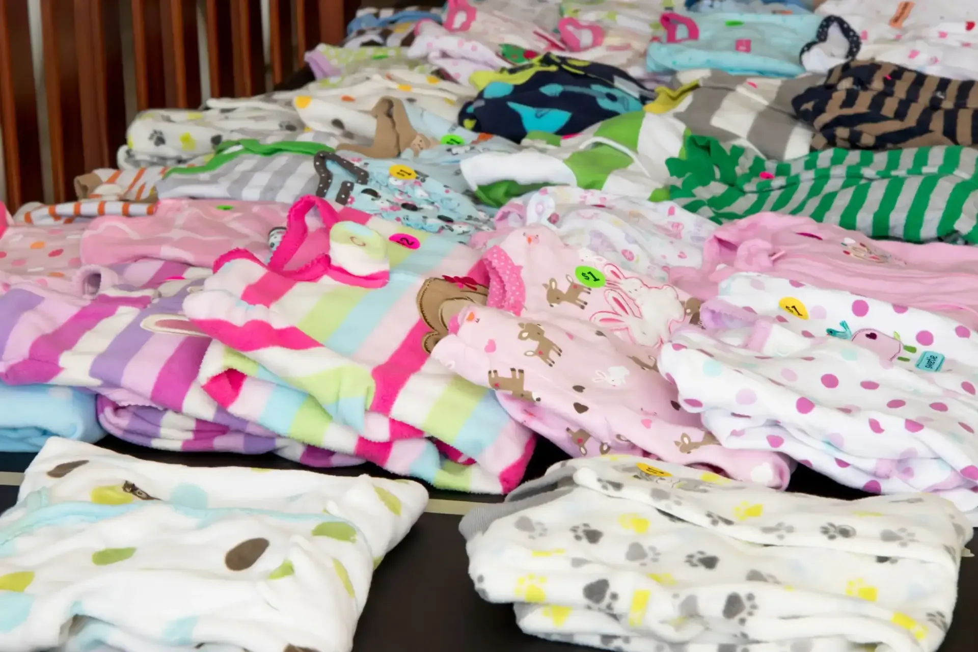 Una pila de ropa de bebé está sobre una mesa.
