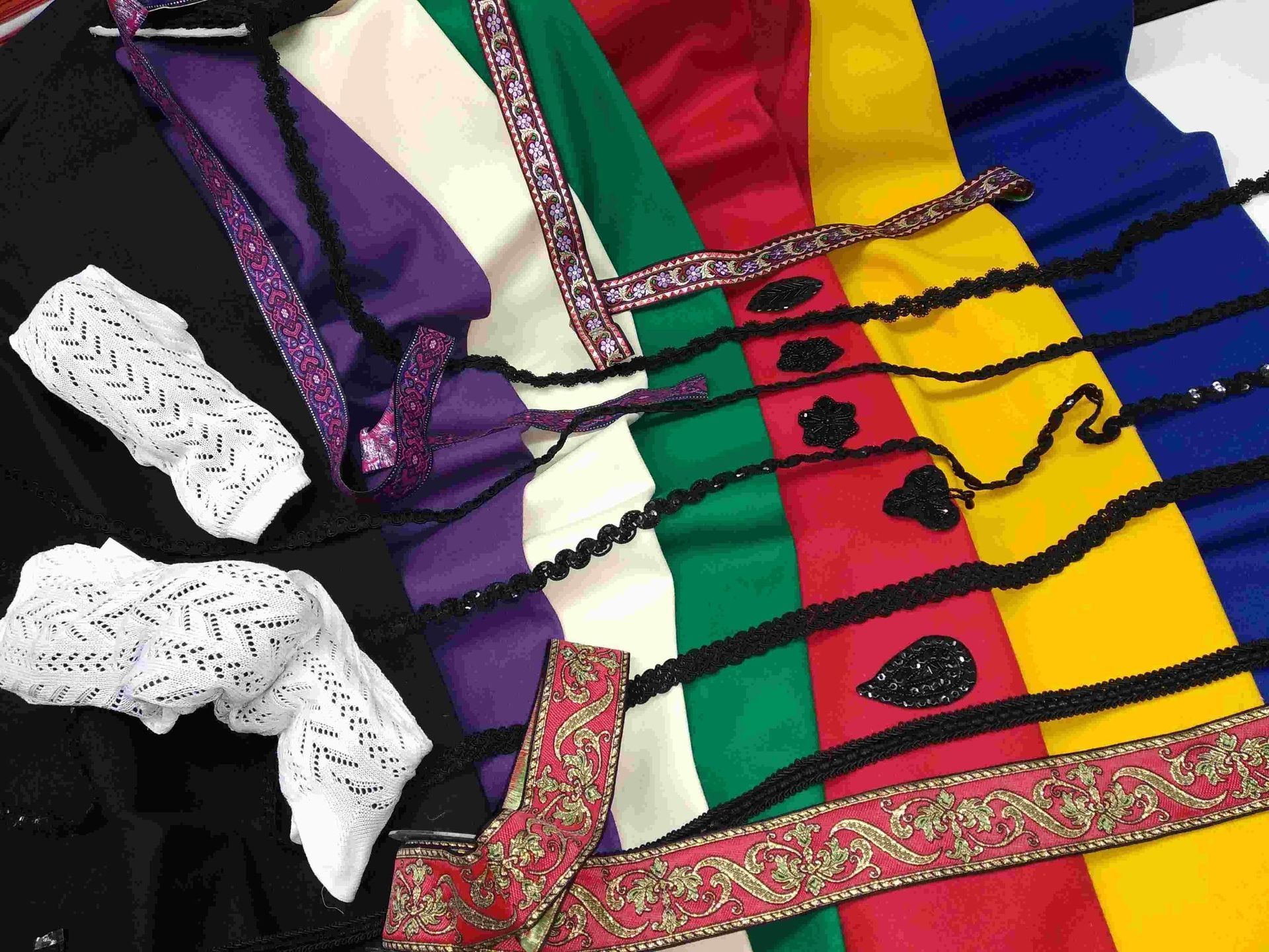 Un montón de telas de diferentes colores están colocadas sobre una mesa.