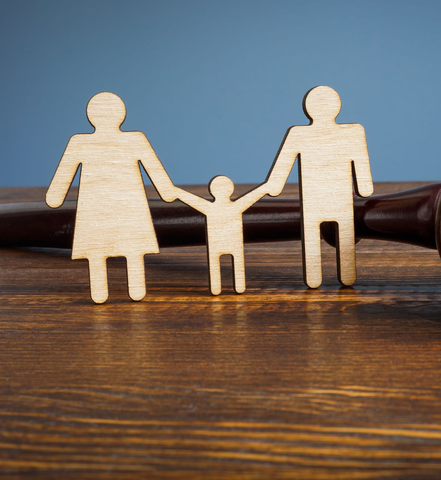 Figurines en bois représentant une famille se tenant la main sur une table.