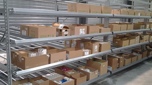 Des étagères d'entrepôt remplies de cartons et de colis dans une allée de stockage.