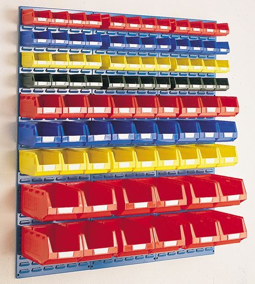 Des rangées de bacs de rangement en plastique colorés fixés au mur d'un atelier ou d'un entrepôt