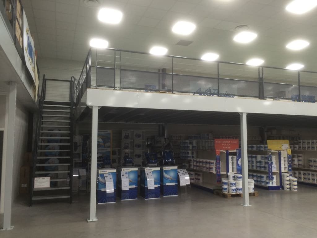 Intérieur d'un magasin en mezzanine avec escaliers, rampes et rangées d'appareils électroménagers emballés en dessous