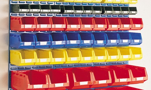 Des rangées de bacs de rangement en plastique colorés (rouges, bleus, jaunes et noirs) sur des étagères métalliques.