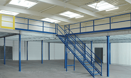 Mezzanine en métal bleu avec escalier dans un entrepôt vide