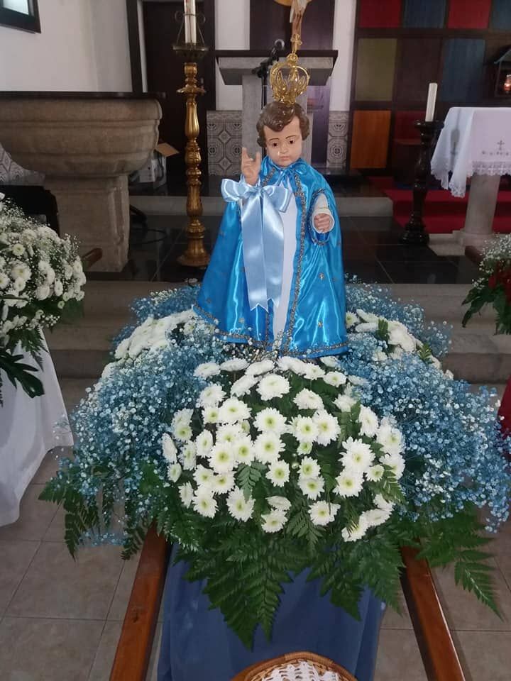 Uma estátua de jesus está cercada por flores em uma Florista Mariazinha - Decoração de Igrejas