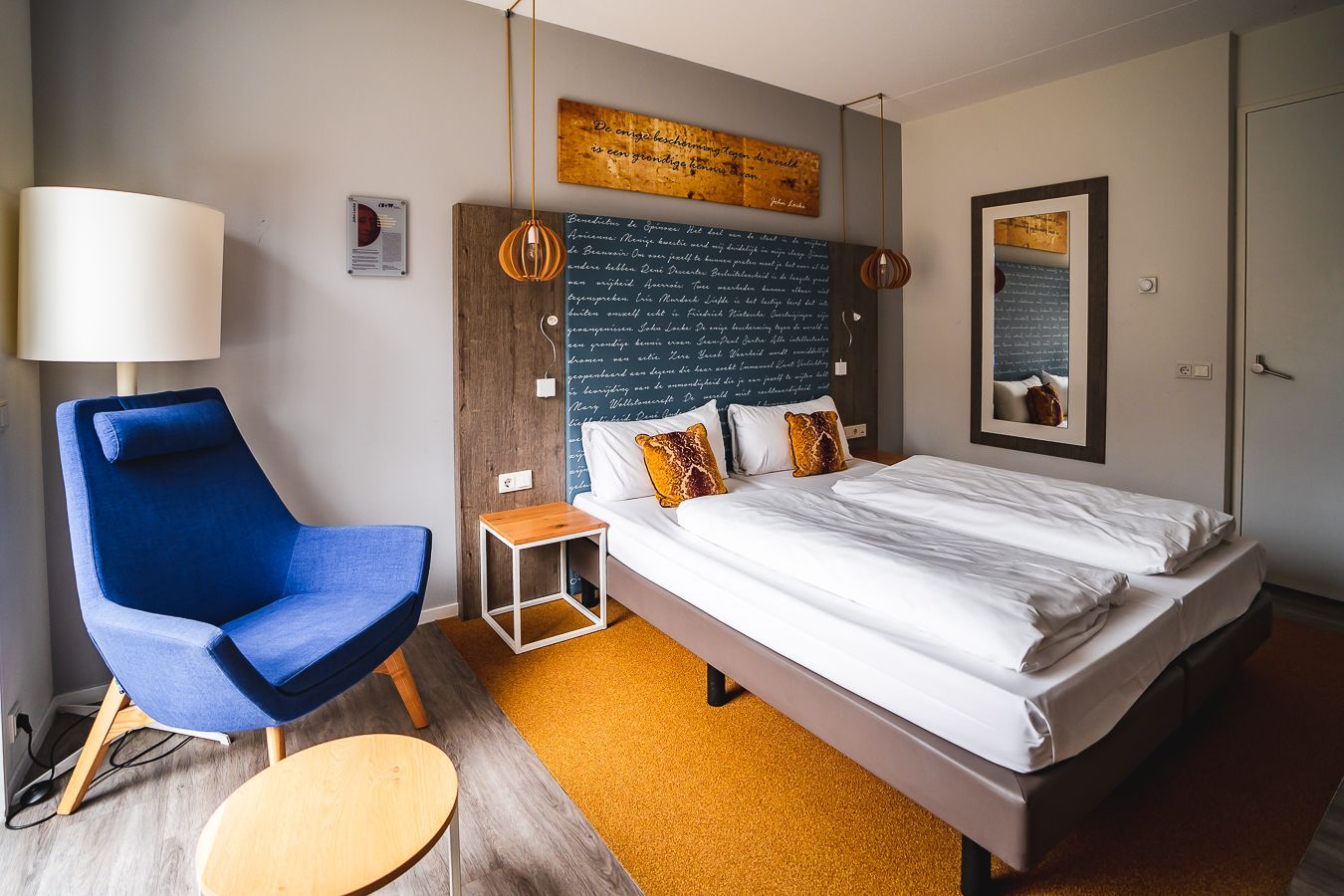 Een hotelkamer met twee bedden, een bureau en een stoel.