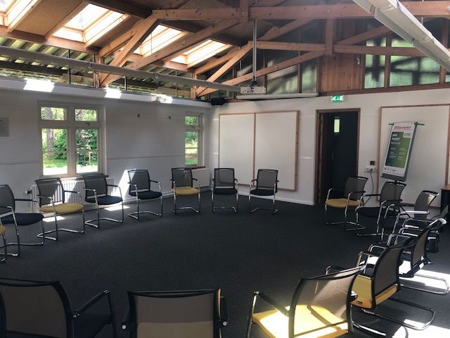 A room with a circle of chairs in it