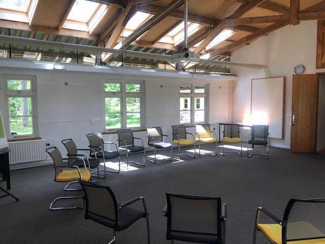 Een kamer met veel stoelen en ramen
