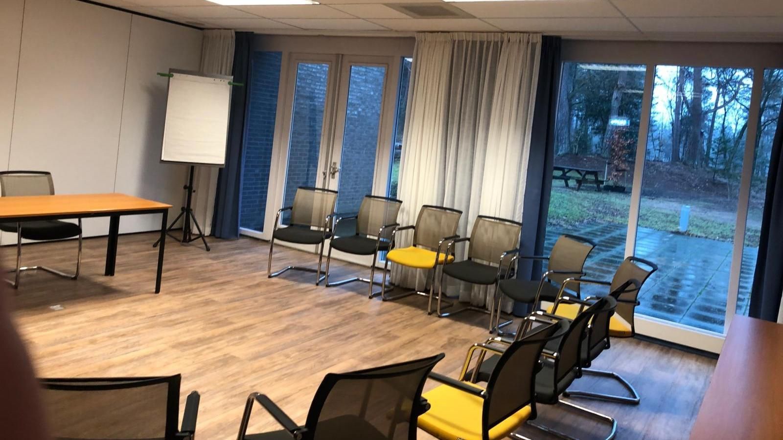 A conference room with a table and chairs and a large window.