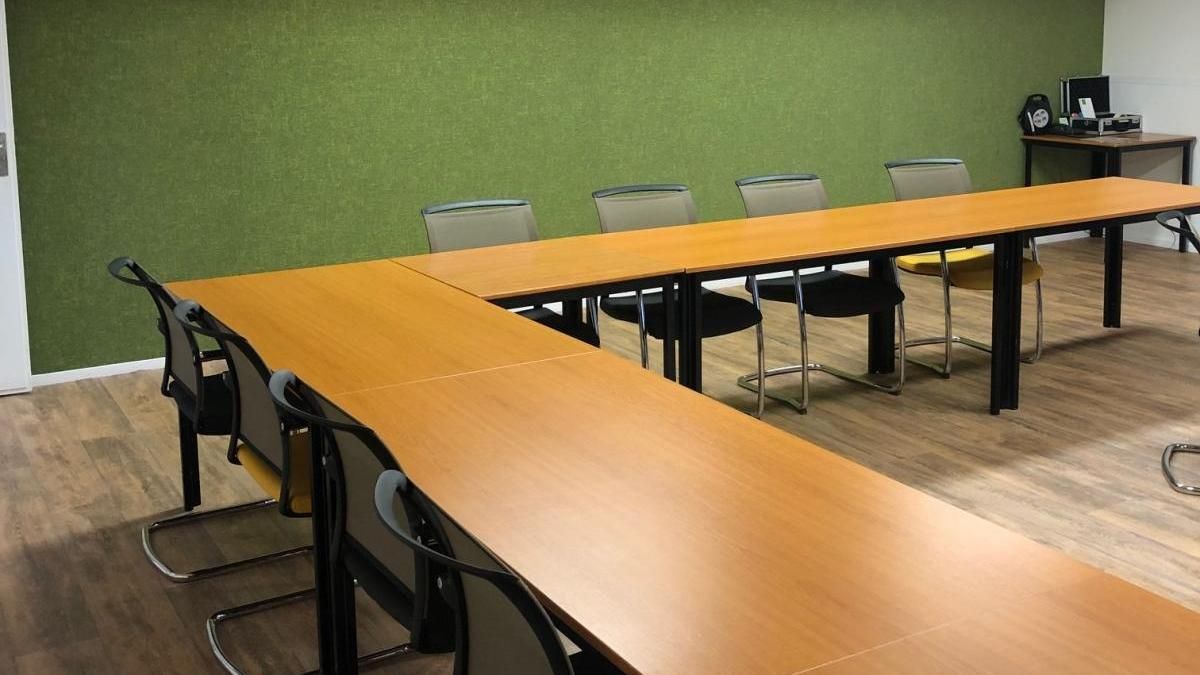 A conference room with a long table and chairs.