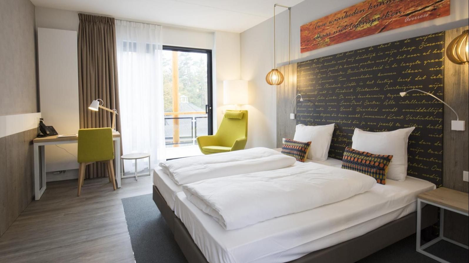 Een hotelkamer met twee bedden, een bureau en een stoel.
