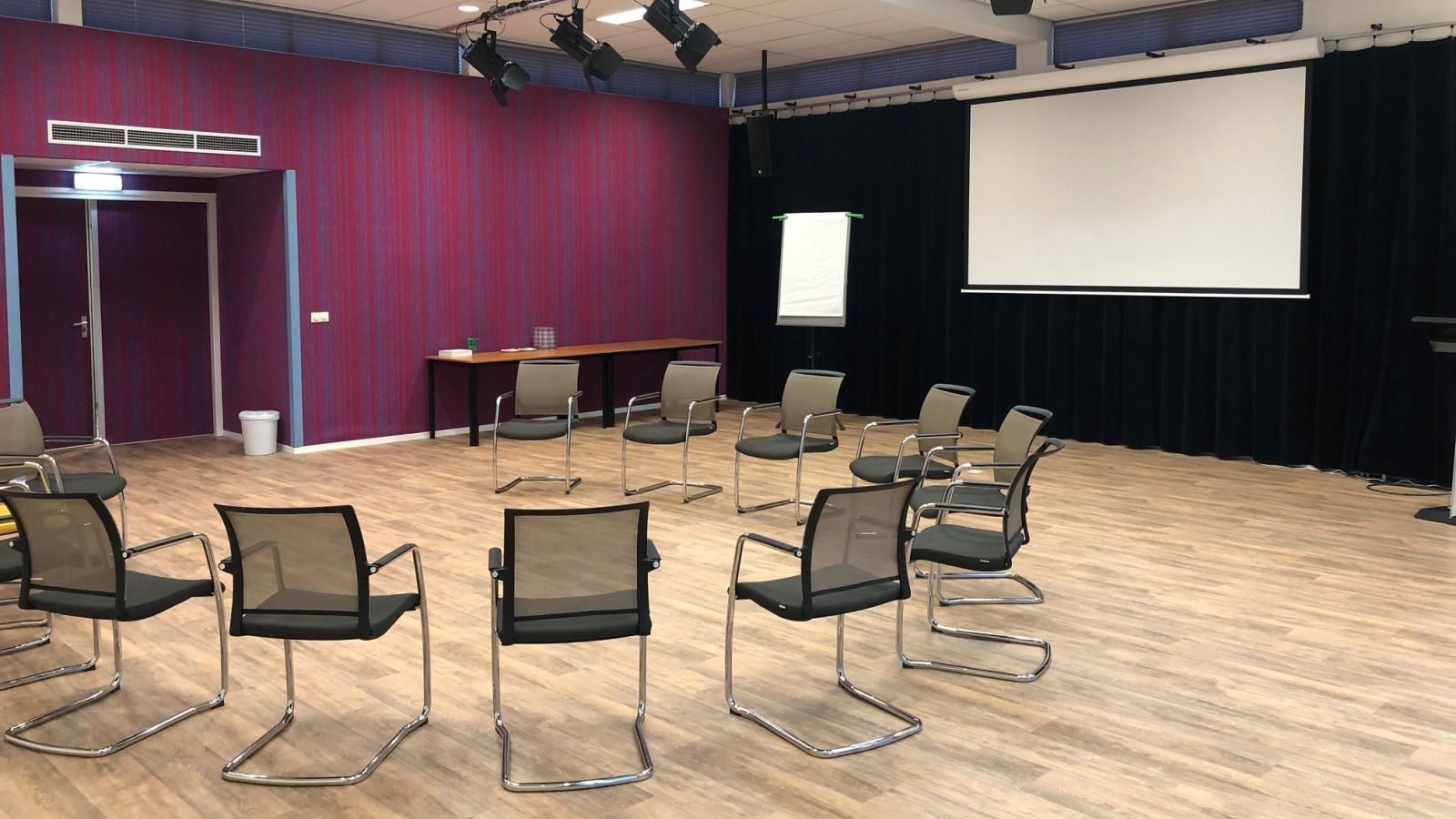A conference room with chairs and a projector screen.