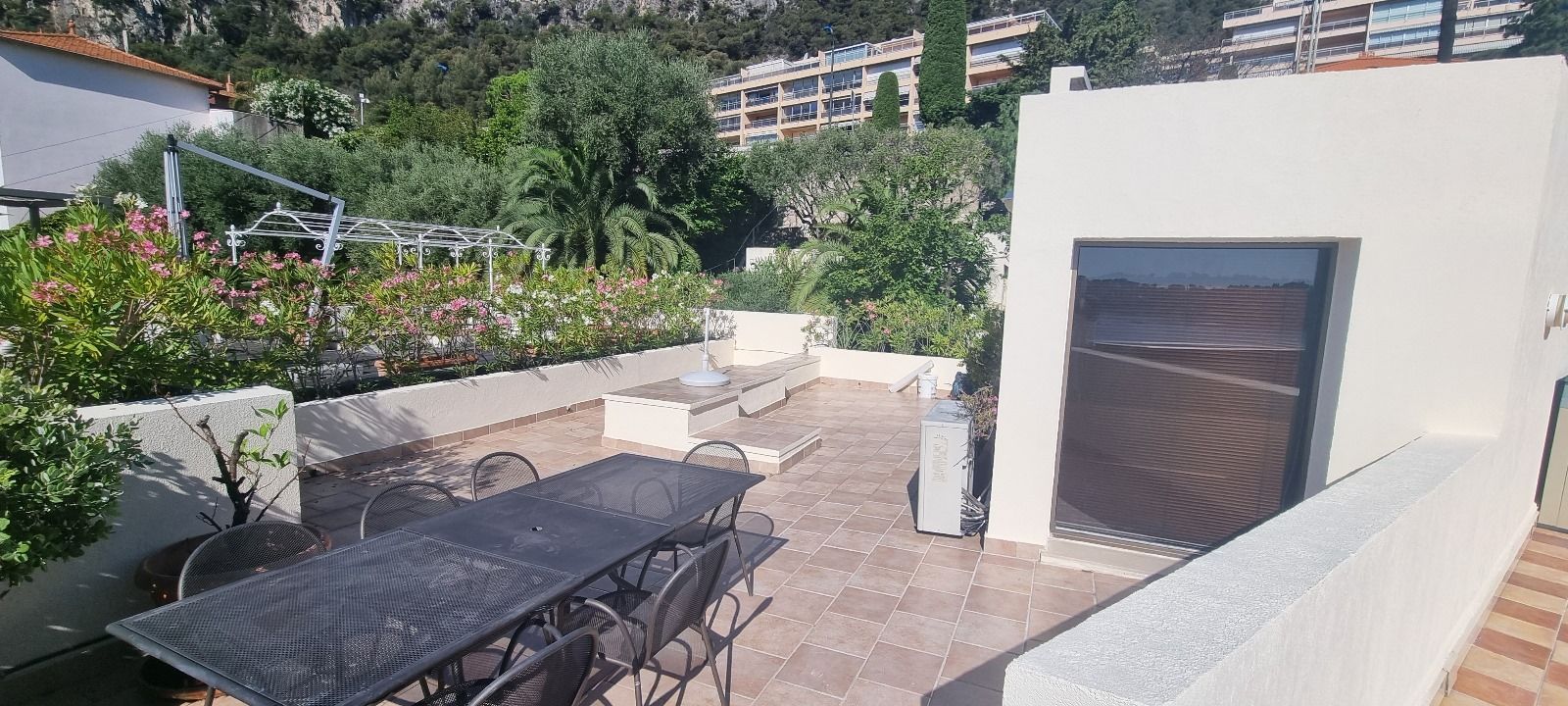 Il y a un patio avec une table et des chaises dessus.