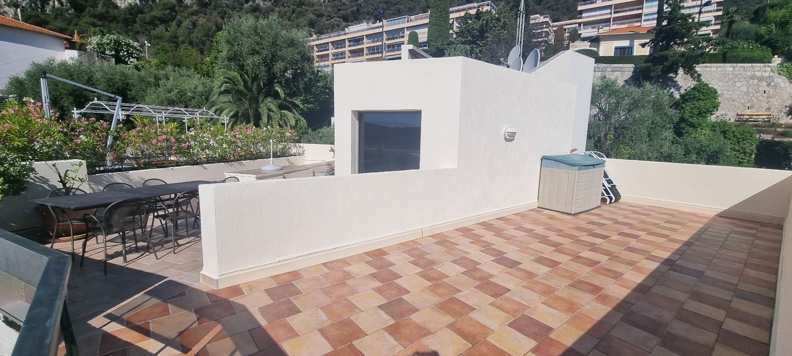 Il y a un patio avec une table et des chaises dessus.