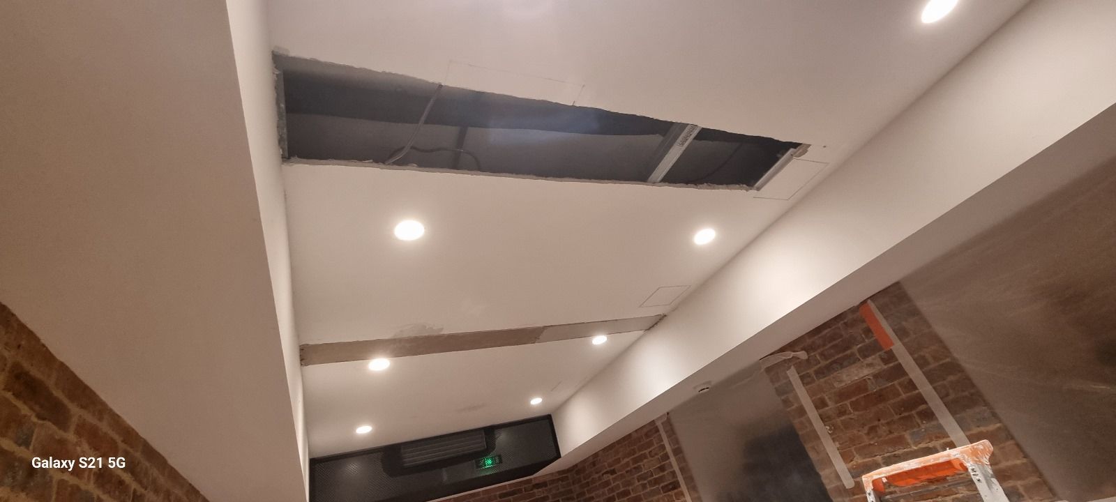 Un plafond avec un trou et des lumières dessus.