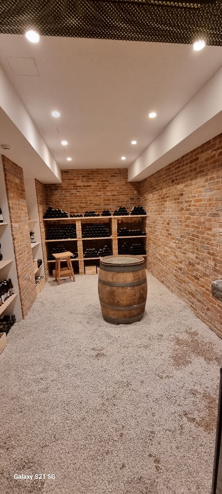 Une cave à vin avec un tonneau en bois au milieu.