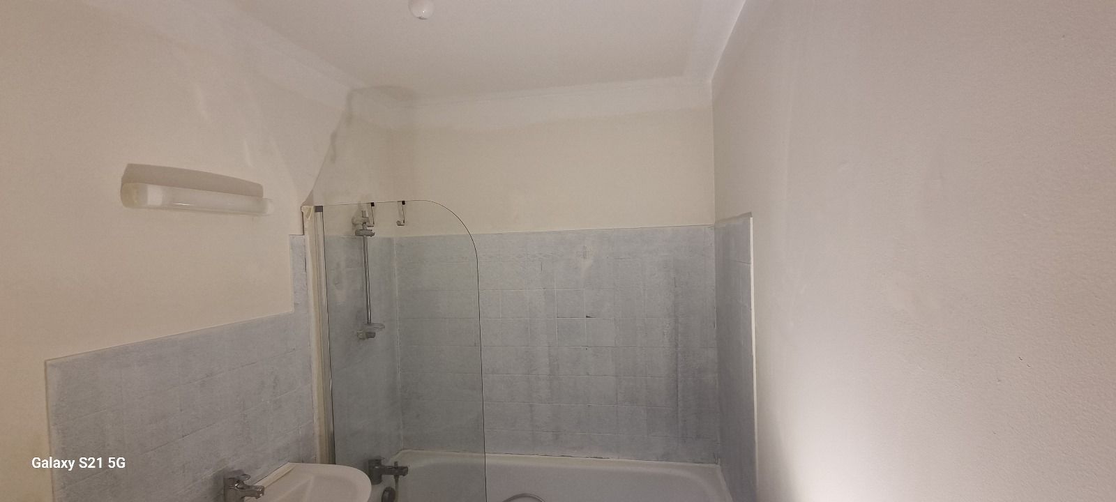 Une salle de bain avec baignoire, WC et douche.