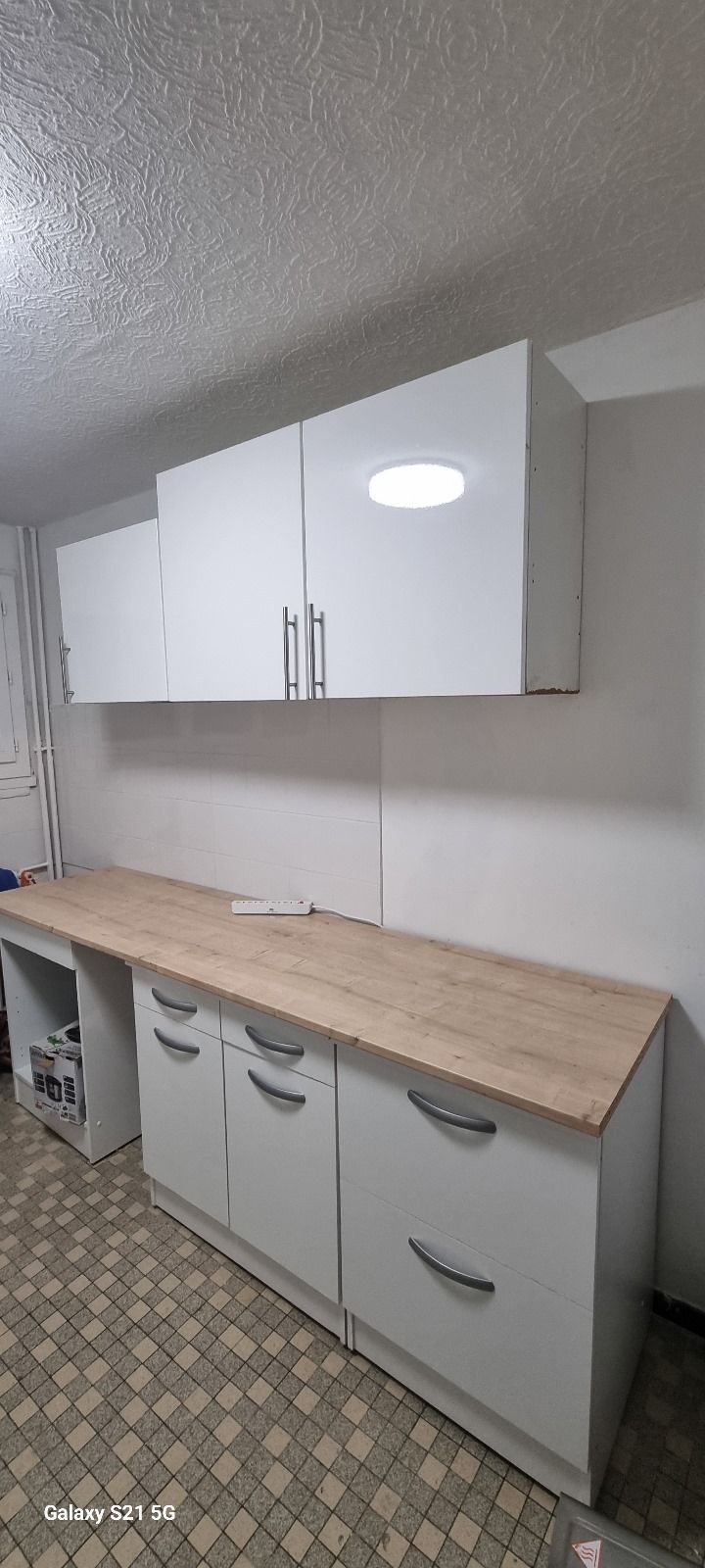 Une cuisine avec des armoires blanches et un comptoir en bois.