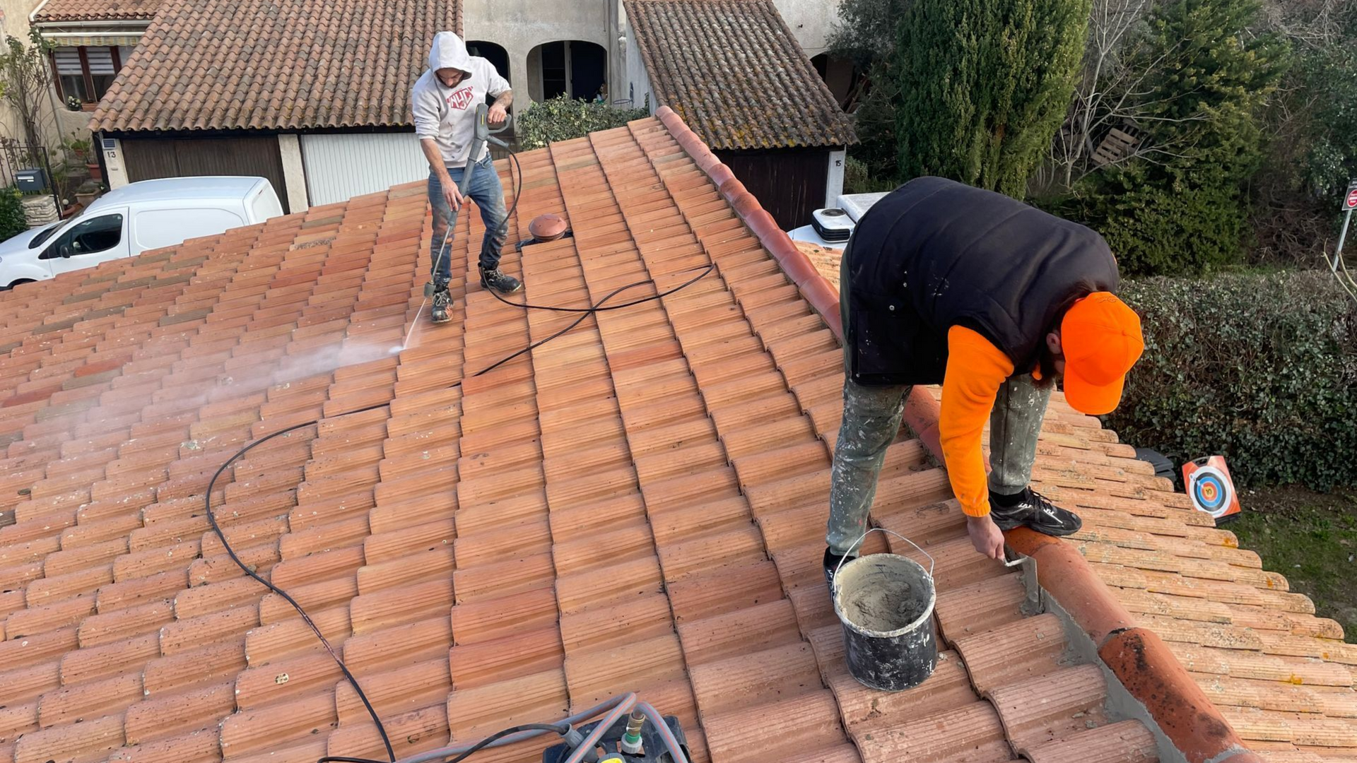 Artisans sur un toit pour le nettoyage et la réparation du faîtage.