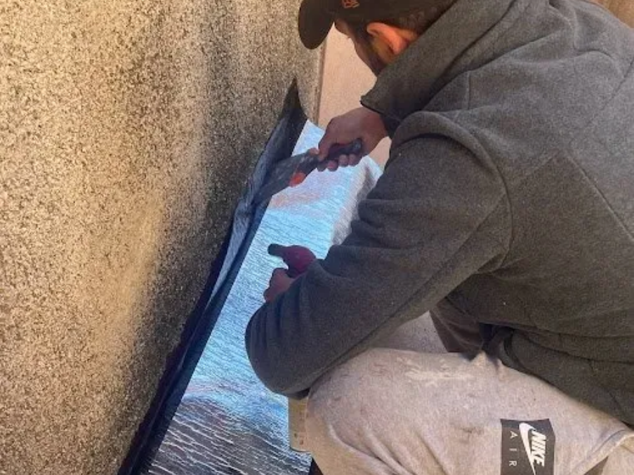 Artisan applique un revêtement étanche sur un toit.