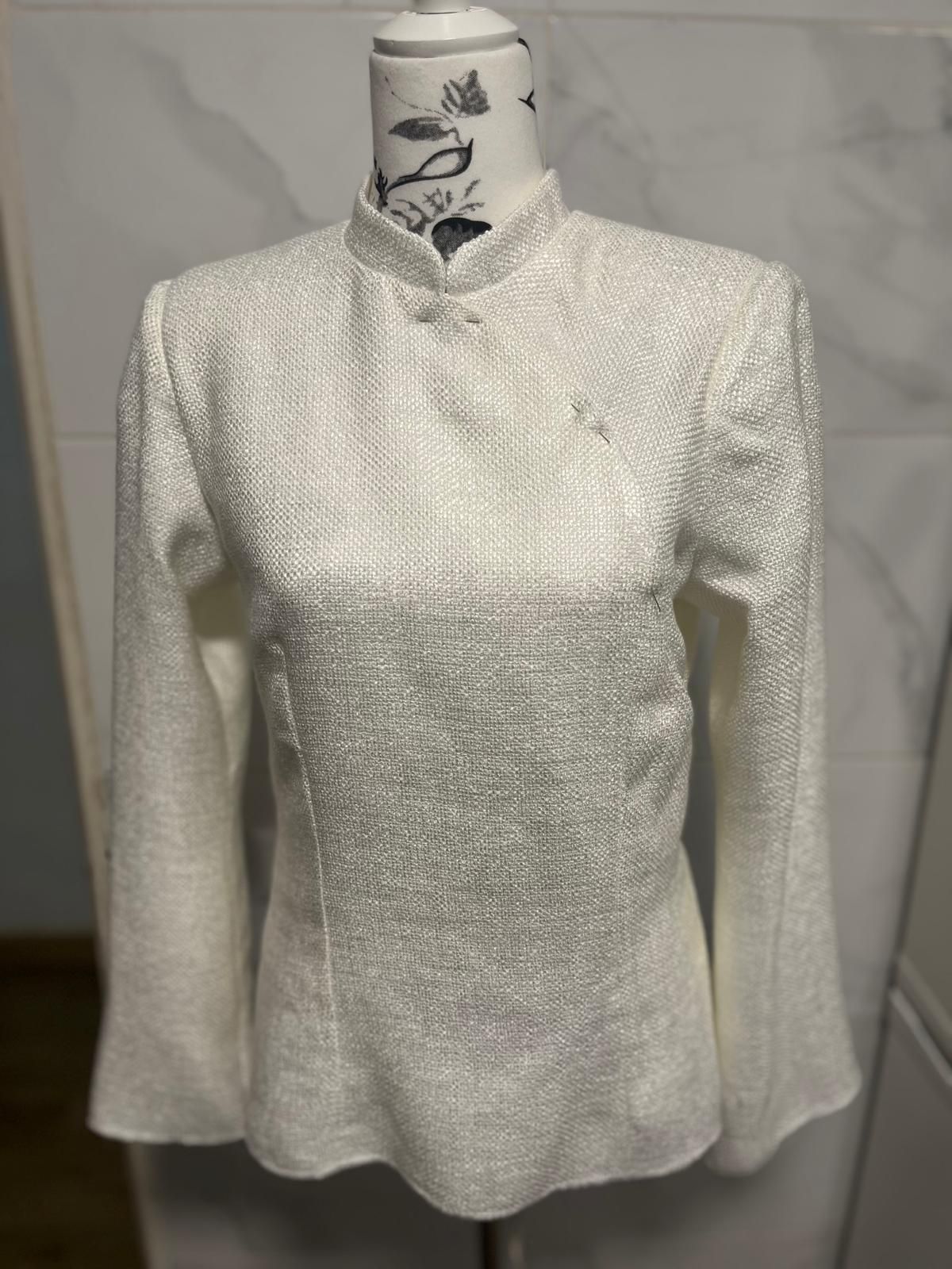 Un suéter blanco está sobre un maniquí.