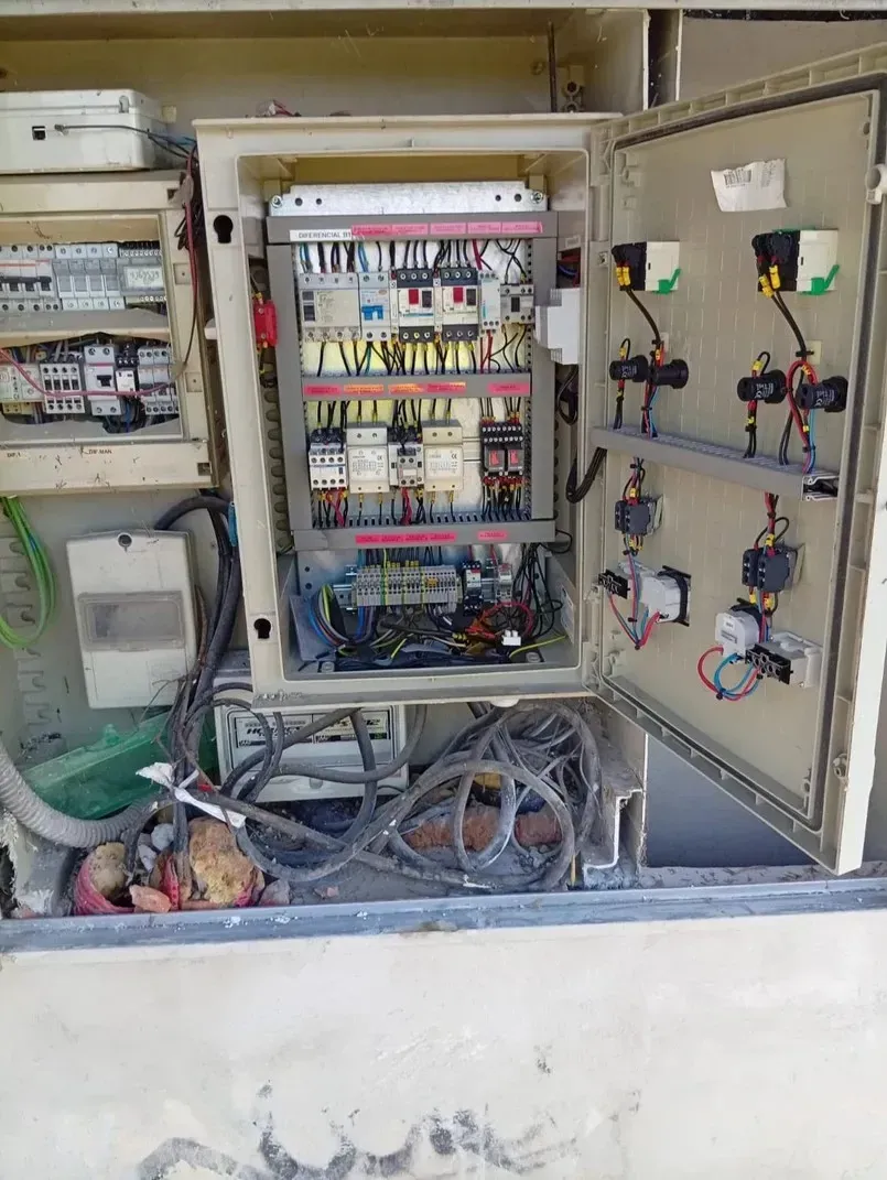 Panel de control eléctrico abierto con cables y componentes. Beige, para exteriores.