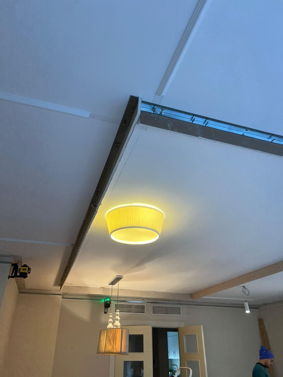 Un techo con pantalla amarilla e iluminación empotrada.