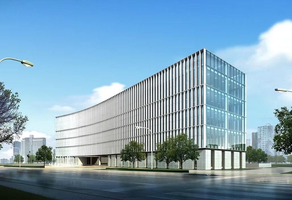 Edificio moderno con muchas ventanas, rodeado de areas verdes y un cielo azul