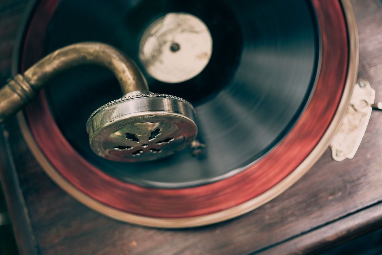 Primer plano de un tocadiscos antiguo con un disco negro giratorio y una bocina de latón.