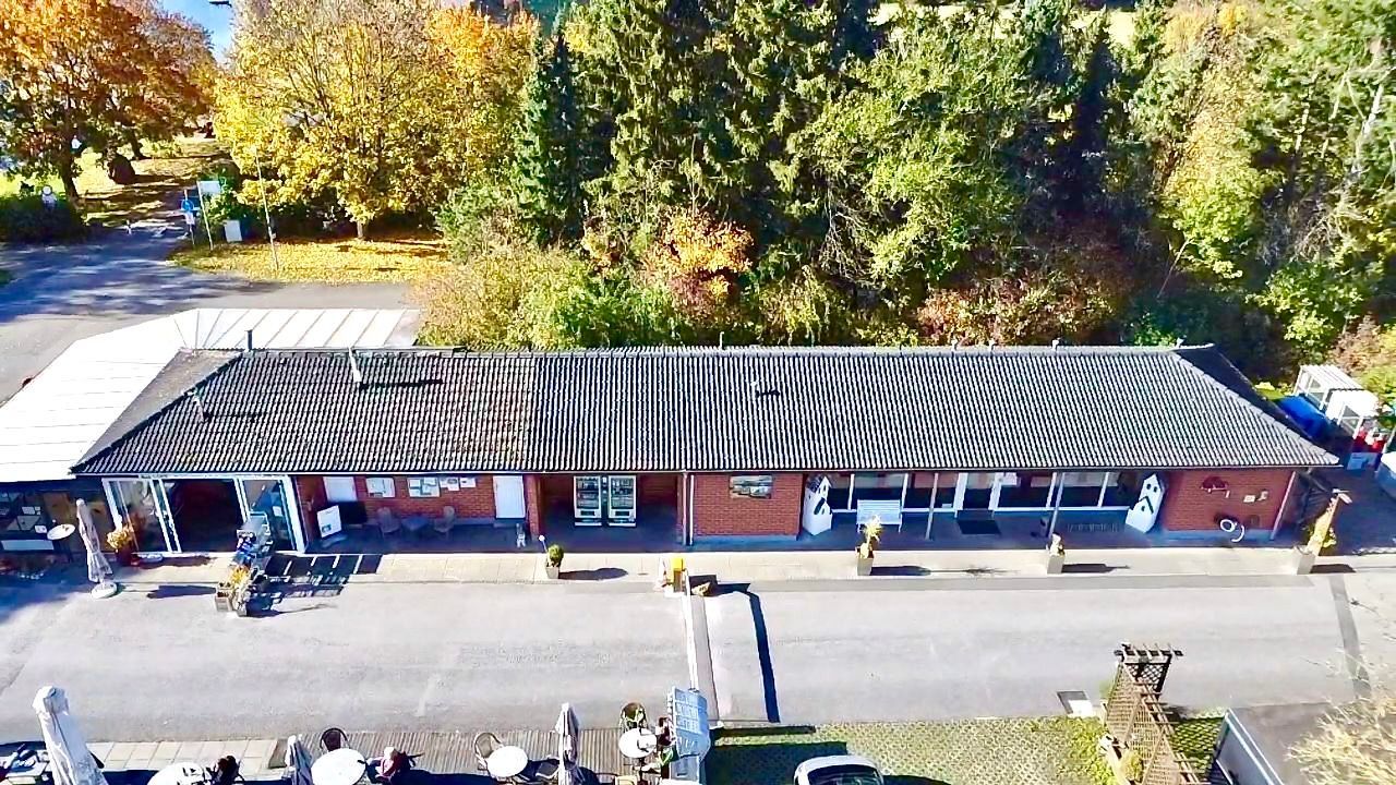 Ein langer Flur mit roten Wänden und weißen Türen