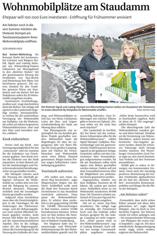 Ein Mann und eine Frau halten ein Bild in einem Zeitungsartikel.