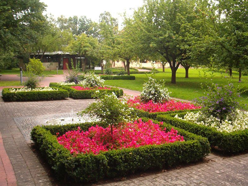 Ein Garten mit rosa und weißen Blumen und Büschen