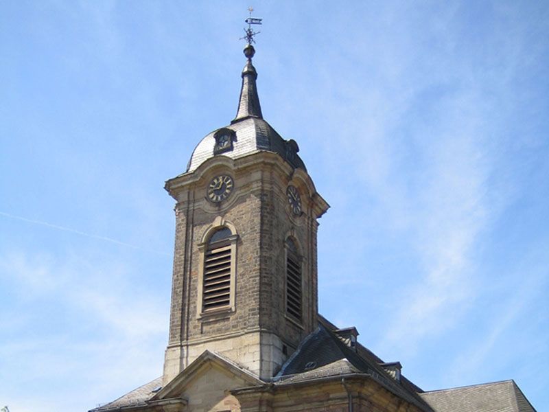 Eine Kirche mit einem Glockenturm und einem Kreuz darauf