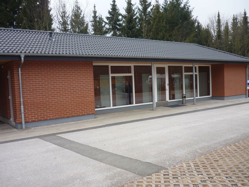 Ein Backsteingebäude mit einem Dach und vielen Fenstern