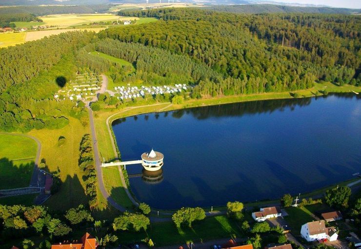 Eine Luftaufnahme eines Sees, umgeben von Bäumen und Häusern