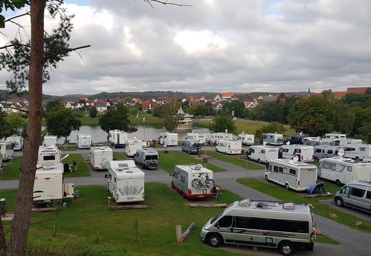 Viele Wohnmobile sind auf einer Rasenfläche geparkt