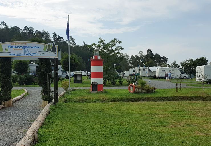 Ein rot-weißer Leuchtturm steht inmitten einer Wiese