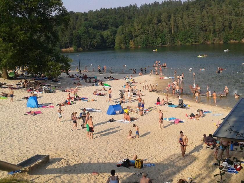Eine große Gruppe von Menschen ist an einem Strand in der Nähe eines Sees