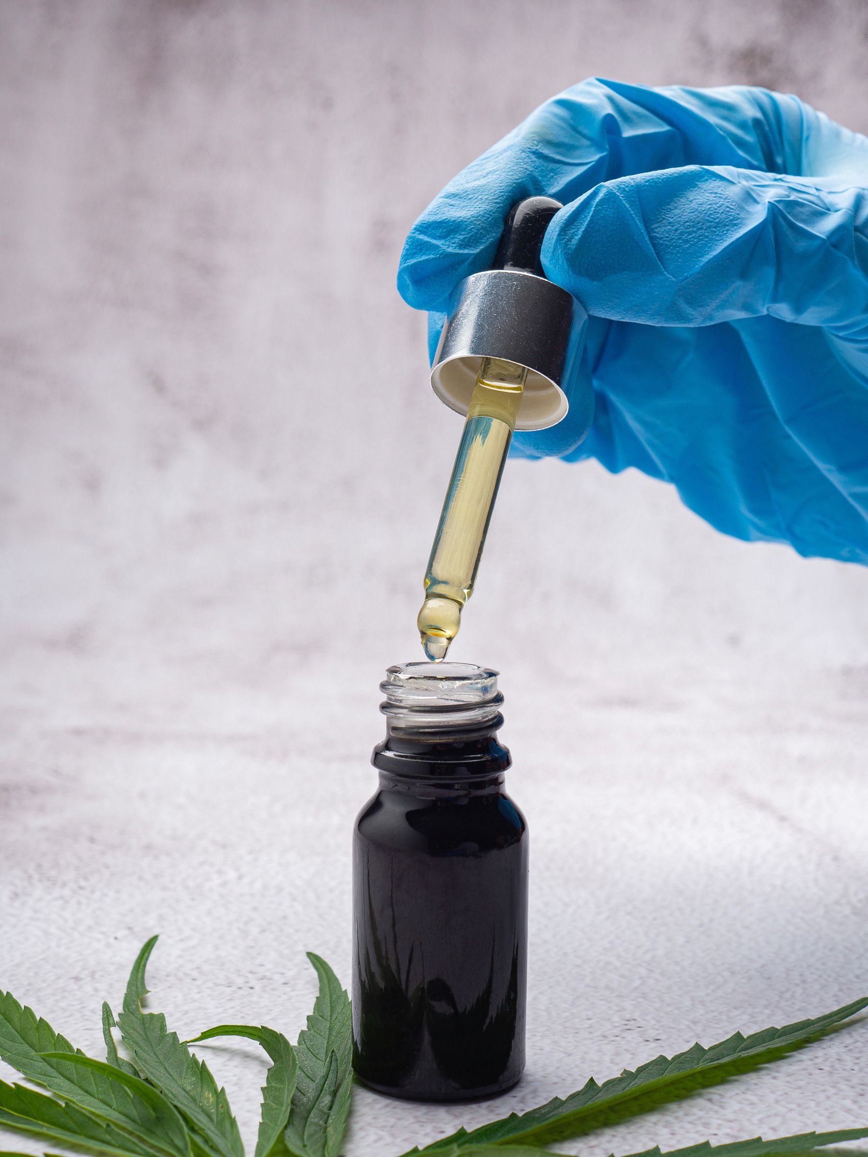 Una persona está vertiendo aceite de una pipeta en una botella.